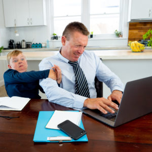 Covid 19 School Lockdowns And Remote Working. Stressed Man Trying To Work From Home With Bored Son