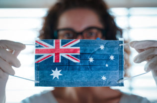 Pandemic Coronavirus. Close Up Of Young Woman With Surgical Mask With The Flag Of Australia On It