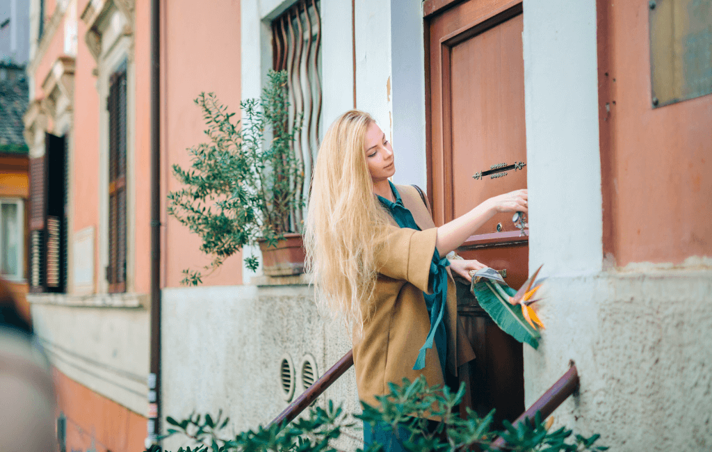 Woman unlocking the door of a residential property representing an inherited family home in Australia.